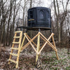 Image of Black blind on a wooden stand in a forest setting